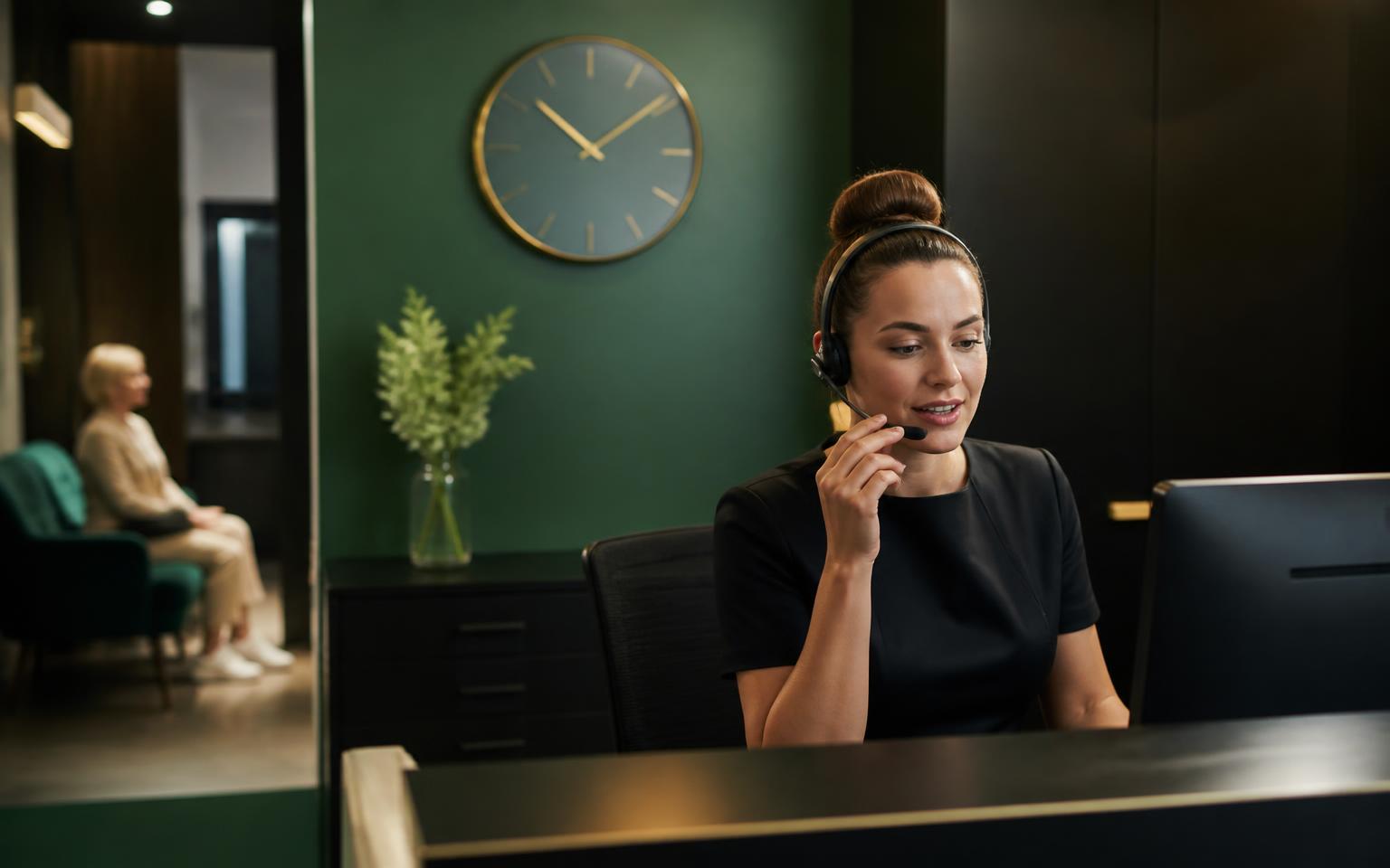 Dental receptionist following up a patient enquiry by phone with a printed follow-up sequence on the desk.